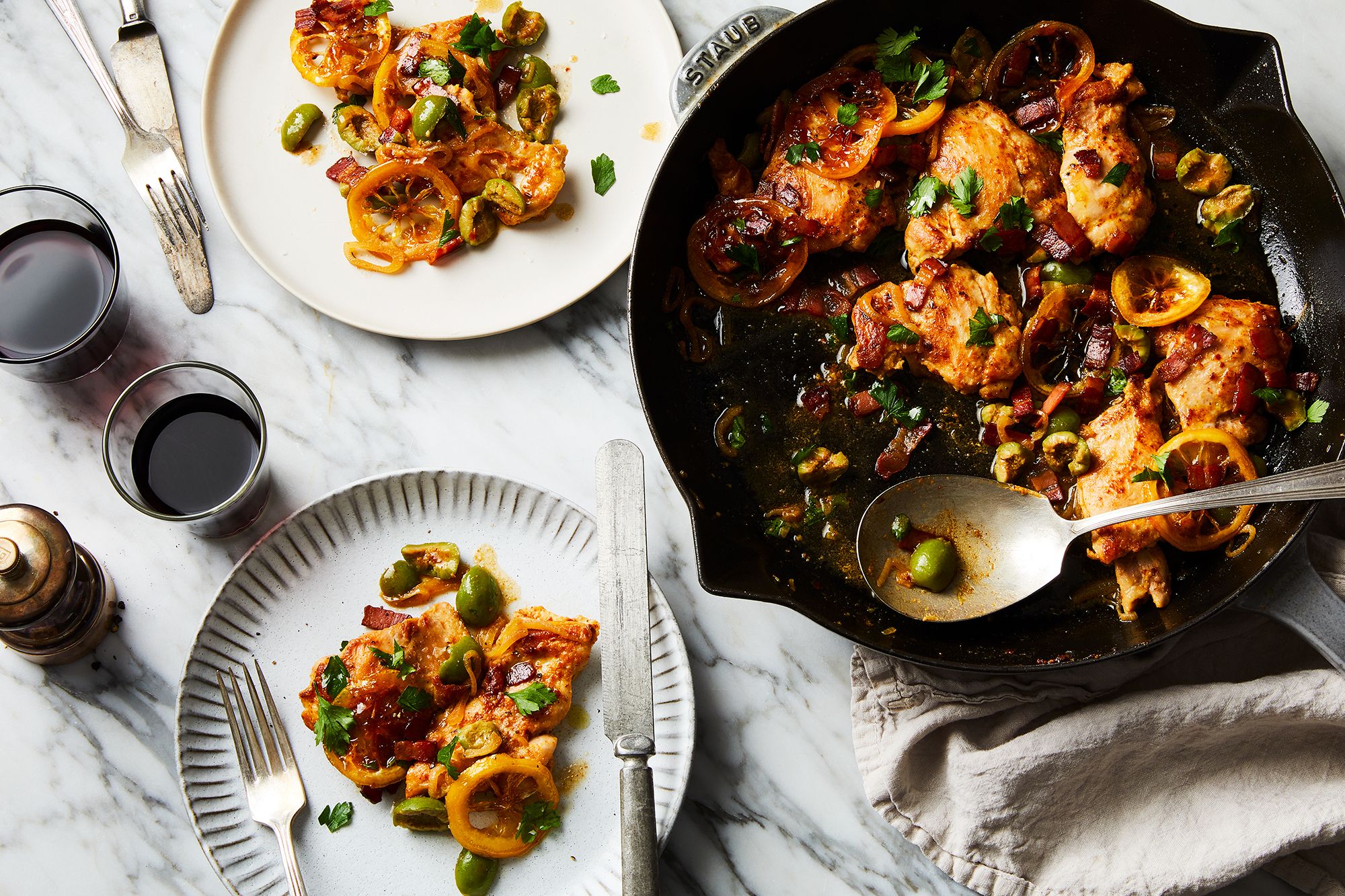 A weeknight dinner setup with a skillet of cooked chicken, a pot of rice, and a tray of roasted vegetables on a home kitchen counter